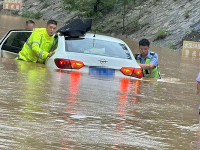 山东费县：轿车过水被淹没 巡逻队员及时伸手救援
